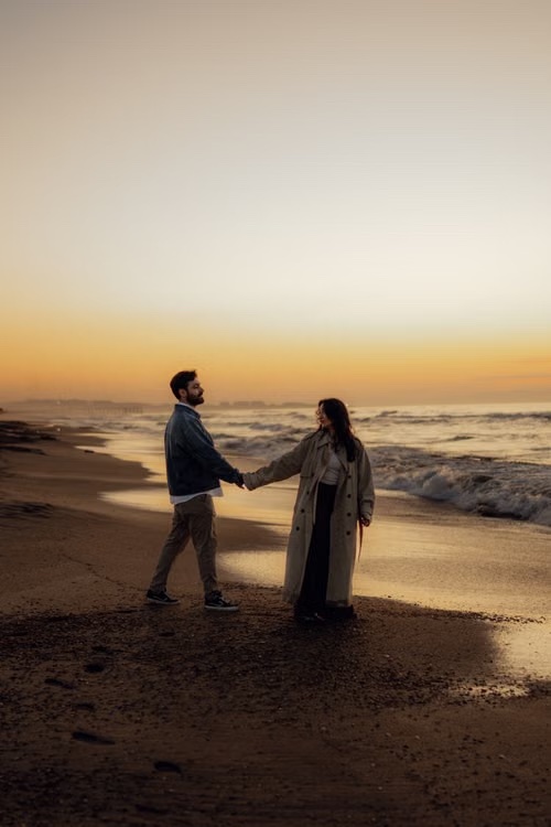 Giovanna ed Enzo mano nella mano sulla spiaggia al tramonto